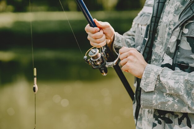 Mann fischt und hält die Angelrute
