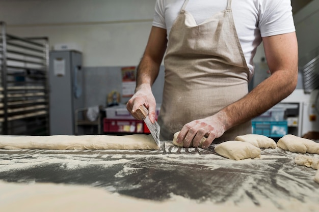 Kostenloses Foto mann fleißig in einer brotbäckerei