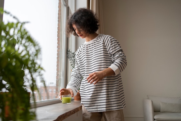 Kostenloses Foto mann genießt zu hause eine tasse matcha-tee