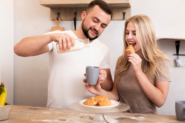 Mann gießt Milch in die Tasse