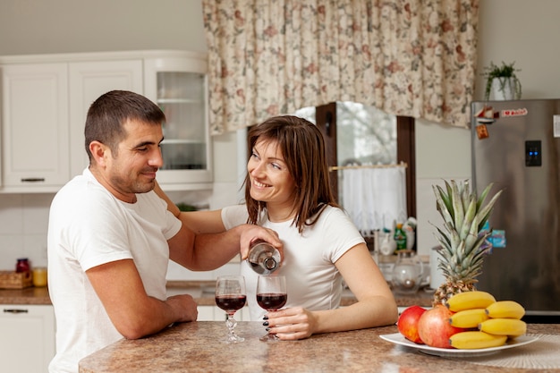 Mann gießt Wein für seine Frau
