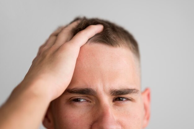 Mann gleitet mit den Fingern durch die Haare