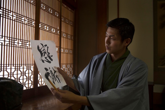 Kostenloses Foto mann hält ein papier mit japanischer handschrift