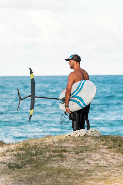 Mann hält ein Surfbrett im Freien