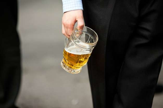 Mann hält eine Bierschale in seiner Hand