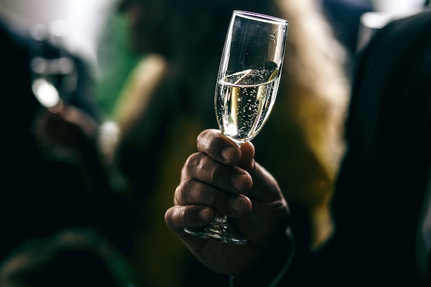 Kostenloses Foto mann hält glas mit champagner