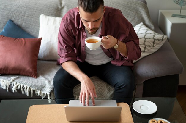 Mann hält Tasse mittlerer Schuss