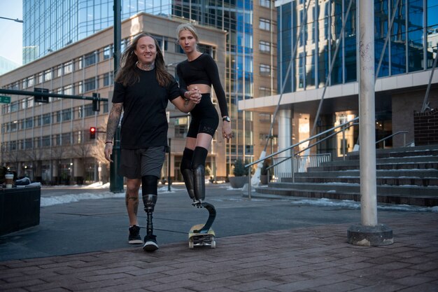 Mann hilft Frau mit Beinbehinderung beim Skateboarden in der Stadt