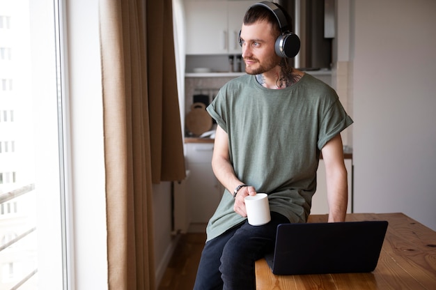 Kostenloses Foto mann hört in seiner freizeit etwas musik über kopfhörer