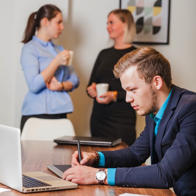 Mann im Anzug sitzt am Schreibtisch arbeiten