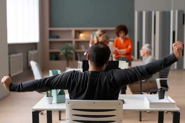 Kostenloses Foto mann im büro, der sich während eines arbeitstages dehnt