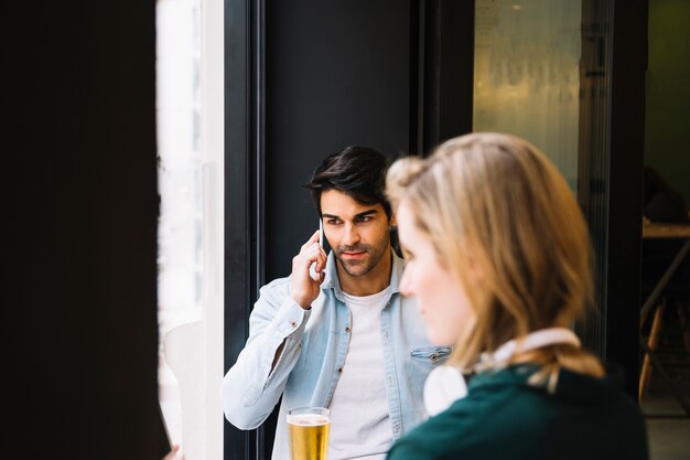 Mann im Café, das auf Smartphone spricht