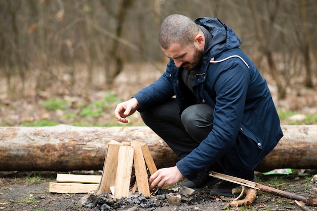 Mann im Freien machen Lagerfeuer