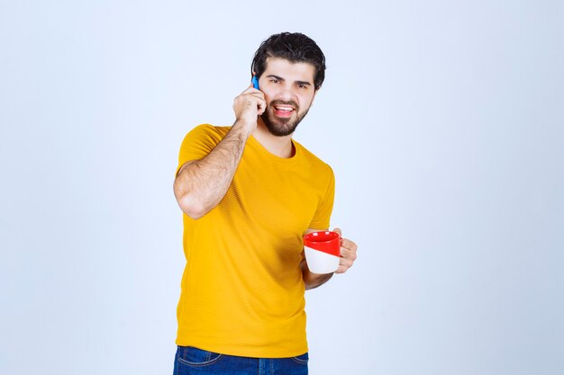 Mann im gelben Hemd, das mit dem Telefon spricht.