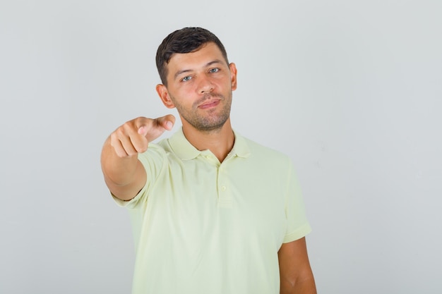 Mann im gelben T-Shirt zeigt Finger auf Kamera und schaut entscheidend