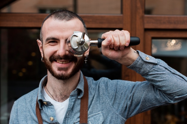 Mann im Vorfeld, das mit Kaffeemaschinenkomponente aufwirft