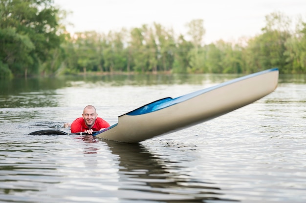 Mann im Wasser nahe Kajak