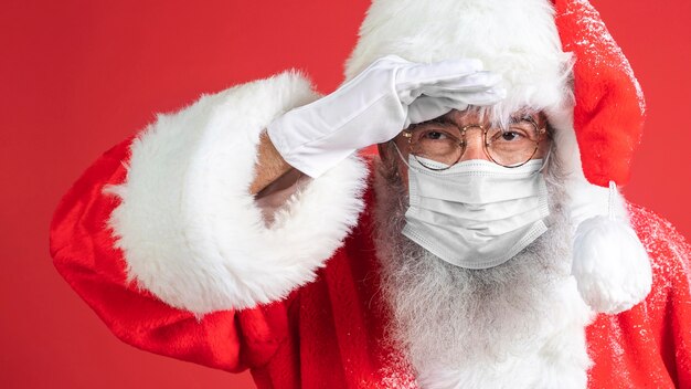 Mann im Weihnachtsmannkostüm, das medizinische Maske trägt