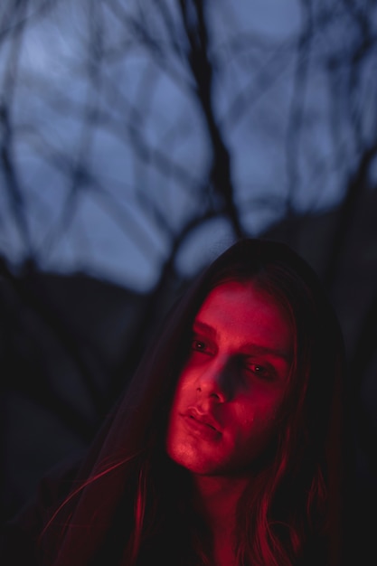 Kostenloses Foto mann in den schatten des roten lichtes, die weg schauen