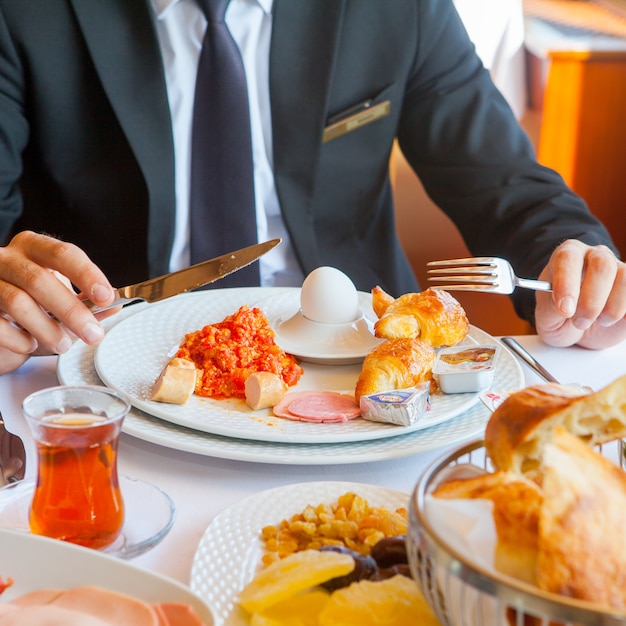 Mann in einem Anzug, der Frühstück in einer Küchenseitenansicht hat