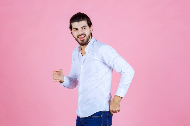 Mann in einem weißen Hemd, das lächelnde und positive Posen gibt.