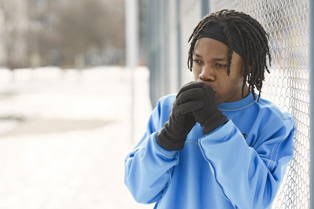 Mann in einem Winterpark. Afrikanischer Typ, der draußen trainiert.