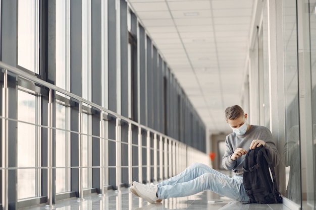 Mann in einer Maske, die in der Halle des Krankenhauses sitzt