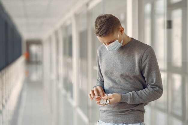 Mann in einer Maske, die in der Halle des Krankenhauses steht