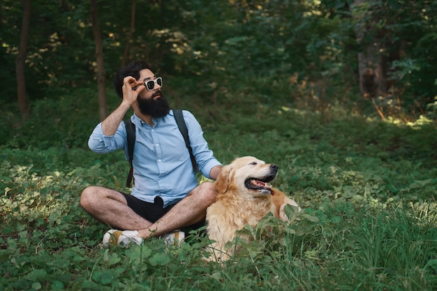 Mann in Freizeitkleidung und sein Hund sehen links überrascht aus