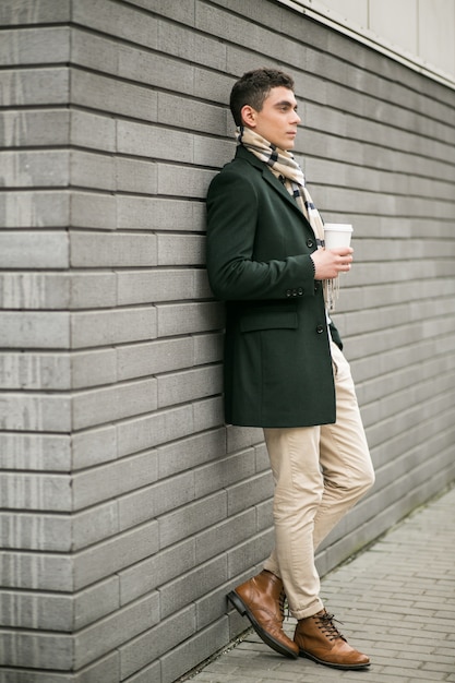 Mann in Jacke mit Kaffee