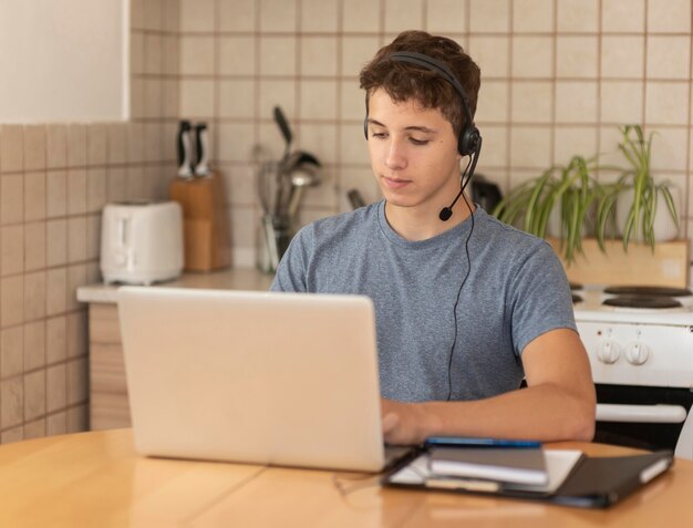 Mann in Quarantäne in der Küche mit Laptop für die Arbeit