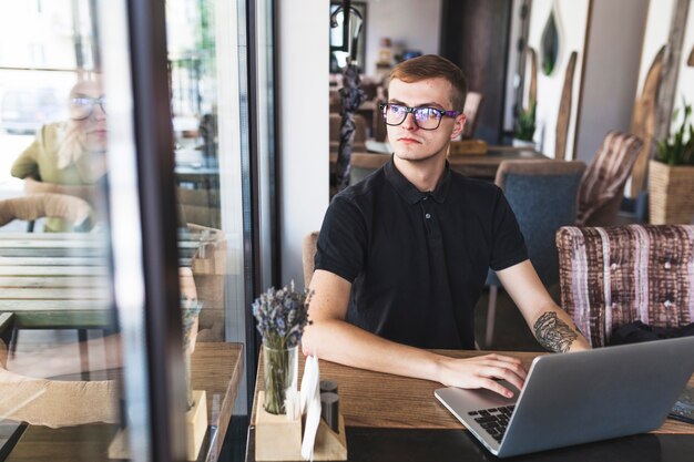 Mann in schwarz am Laptop arbeiten