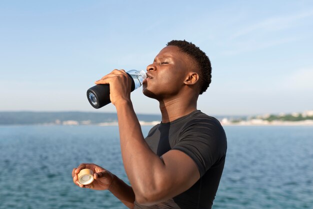 Mann in Sportkleidung mit einer Flasche Wasser