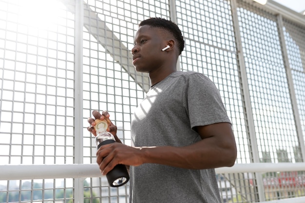 Mann in Sportkleidung mit einer Flasche Wasser