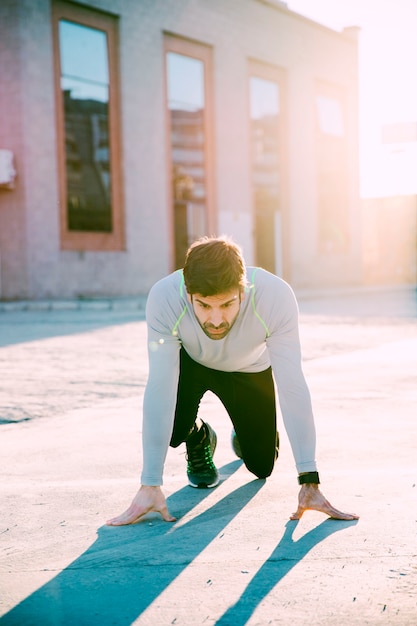 Mann in Startposition vor dem Sprint