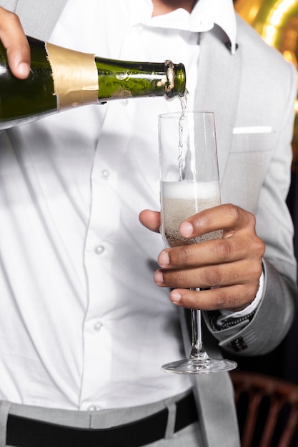 Mann in strömendem Champagner der schönen Klage in einem Glas