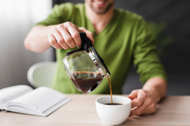 Mann in strömender Kaffeenahaufnahme des grünen Hemdes