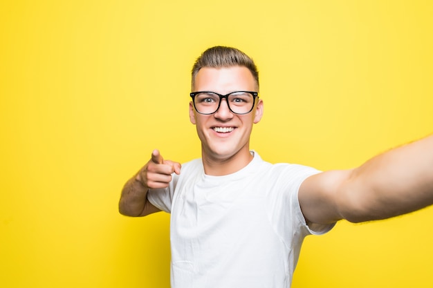 Mann in weißem T-Shirt und Brille macht etwas auf seinem Telefon und macht Selfie-Bilder, die Telefon halten