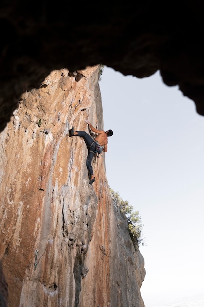 Mann klettert auf einen Berg mit Sicherheitsausrüstung