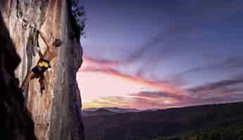 Kostenloses Foto mann klettert auf einen berg mit sicherheitsausrüstung