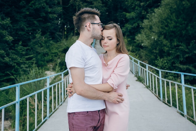 Mann küssen im Gesicht sein Mädchen auf einer Brücke