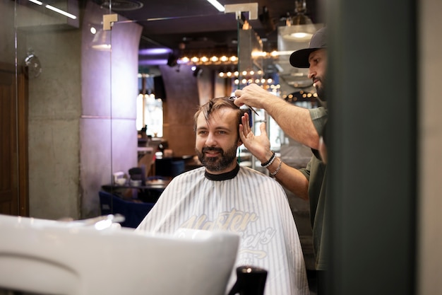 Mann lässt sich beim Friseur die Haare schneiden4