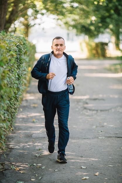 Mann läuft auf einer Gasse im Park