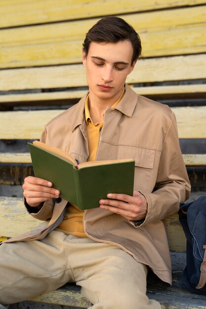 Mann liest Buch im Freien, Vorderansicht