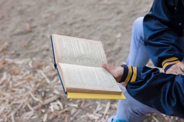 Mann liest ein Buch draußen