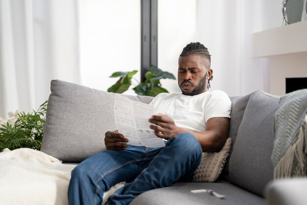 Mann liest zu Hause die Anweisungen für einen Covid-Test