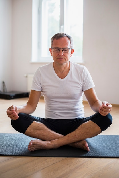Mann mit Augen schloss übendes Yoga