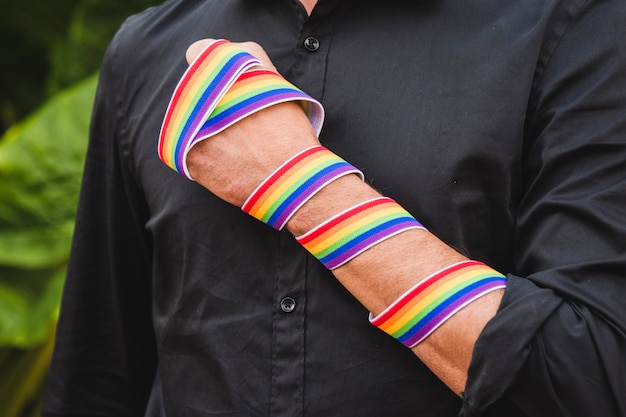 Mann mit Band in LGBT-Farben an Hand