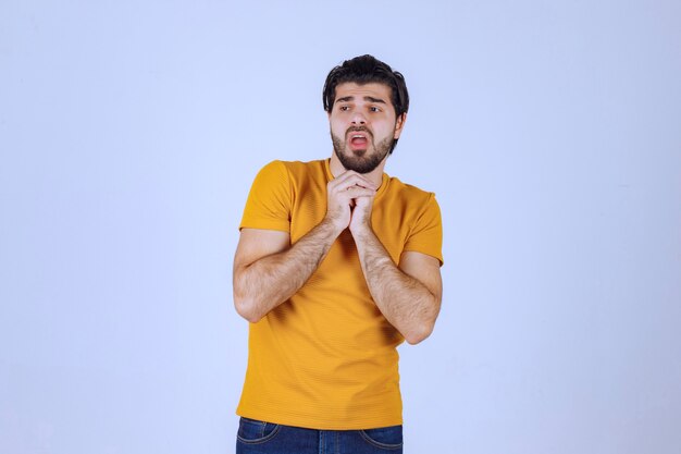 Mann mit Bart, der seine Hände vereint und betet und um etwas bittet