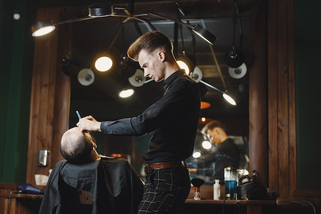 Mann mit Bart. Friseur mit einem Kunden. Mann mit einer Rasur.